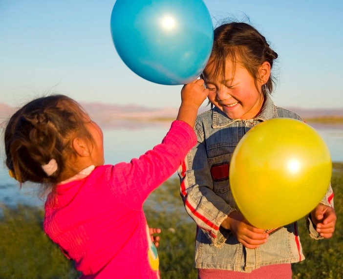 two young girls playing with balloons